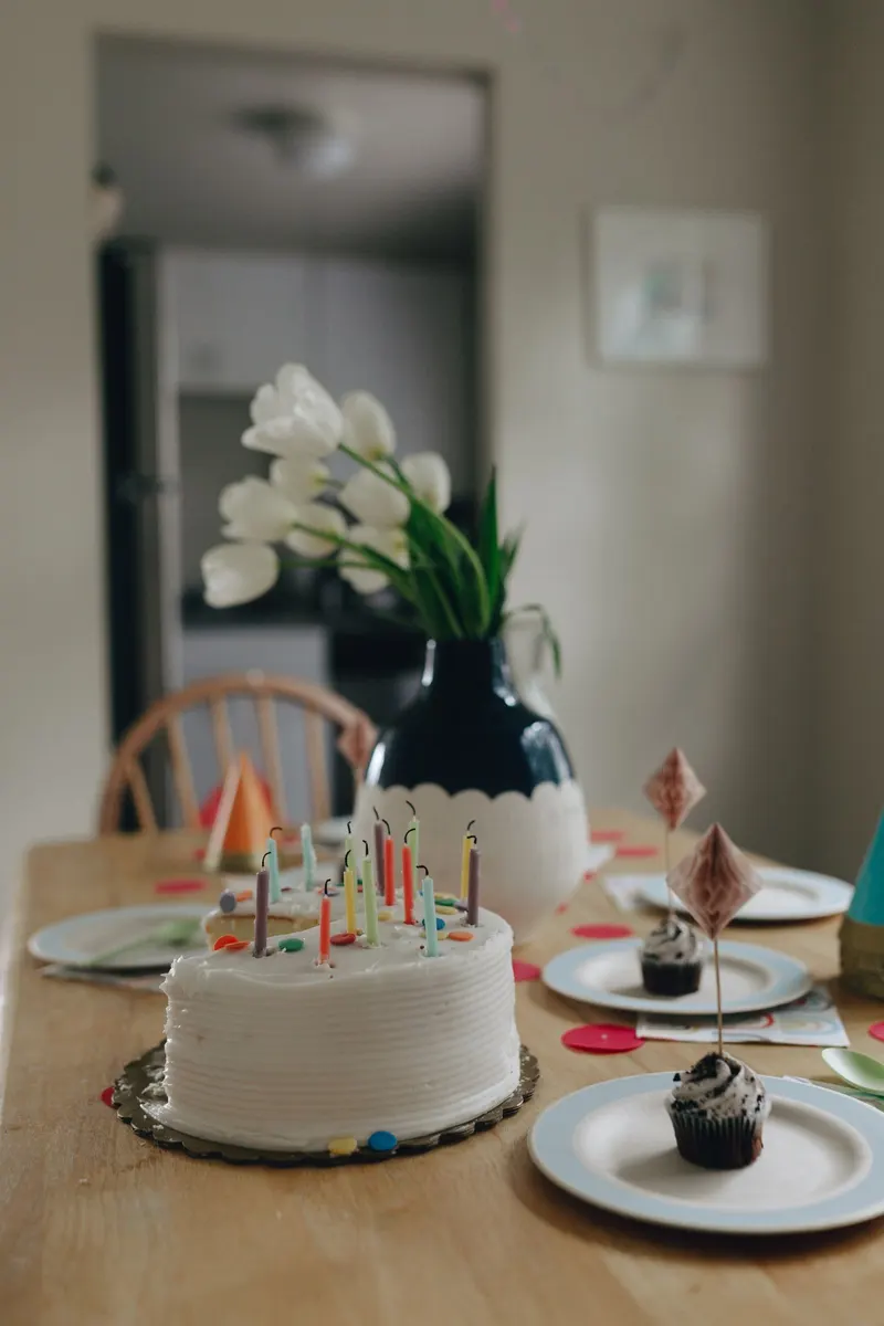 Bursdagskake med lys på et pyntet bord